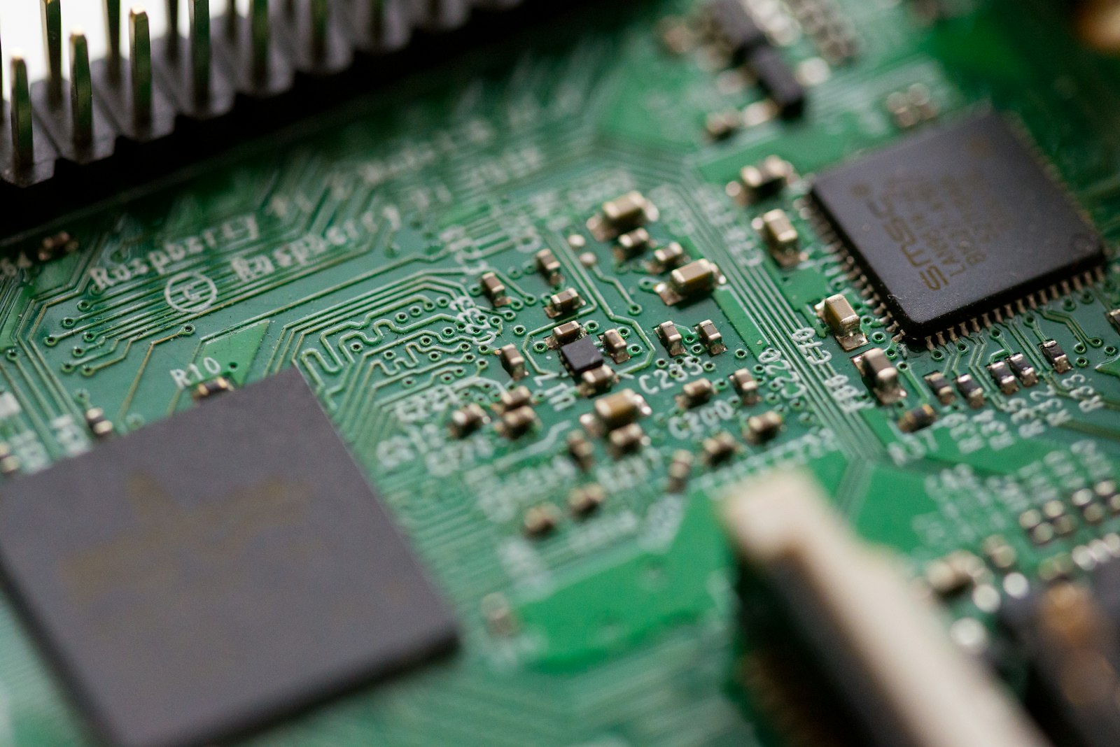Close-up of flash memory chips and components on a green PCB with shallow depth of field